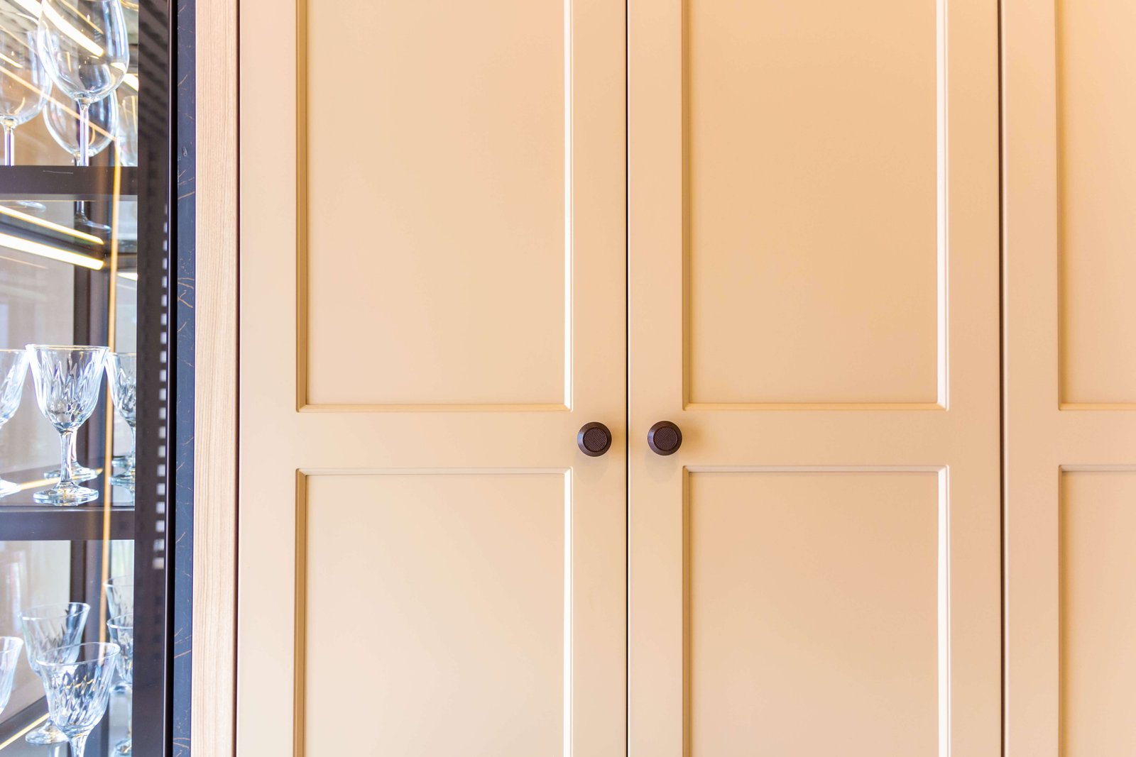 Armário planejado com portas emolduradas em tom creme e puxadores redondos, um projeto de marcenaria da Zogbi Móveis em São Paulo.