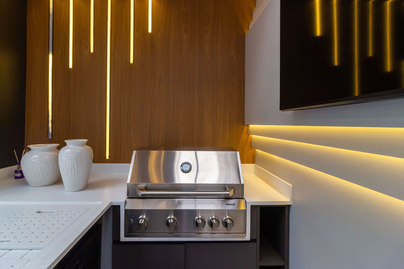 Painel de madeira com nichos decorativos e jardim vertical integrado, parte de um projeto de interiores sofisticado em São Paulo.